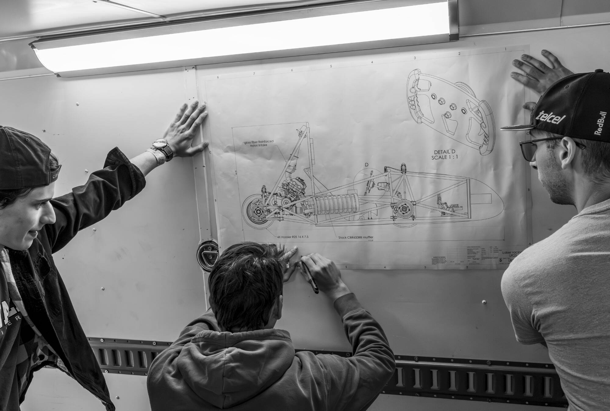 Mechanical engineering majors Jacob Veine, David Rockel and Joshua Allen, sign design schematics for teammates as souvenirs after the Formula SAE competition